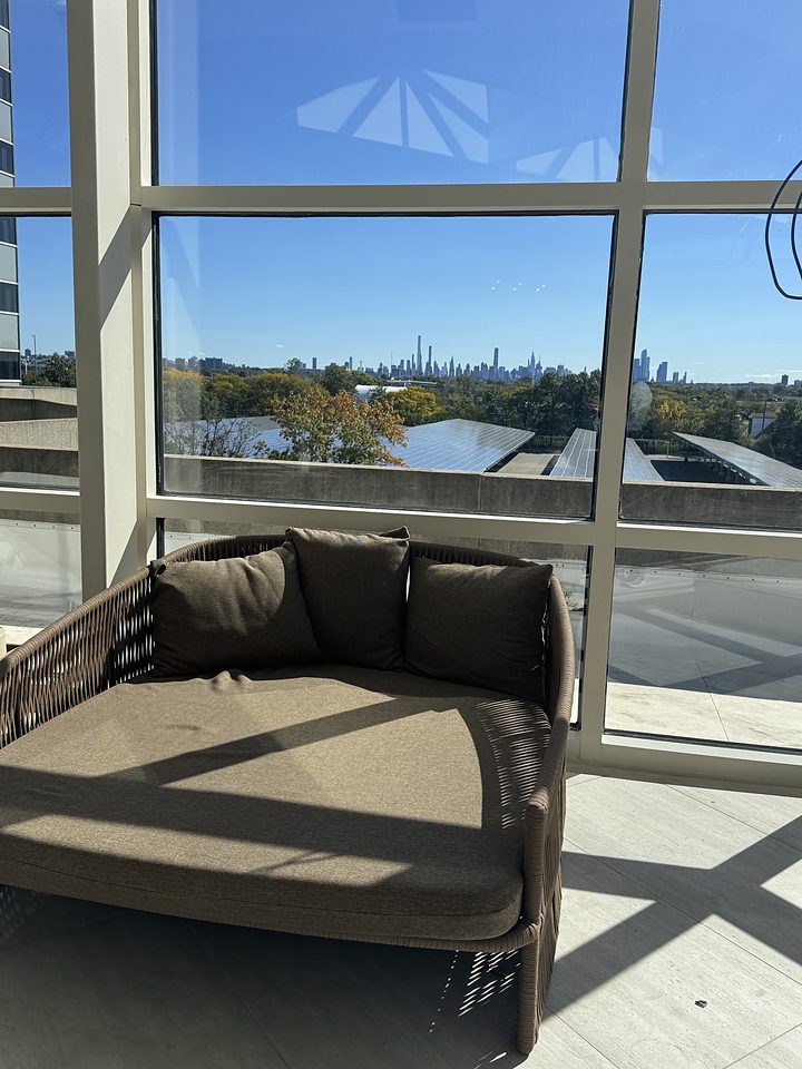 A poolside daybed with a view toward the city