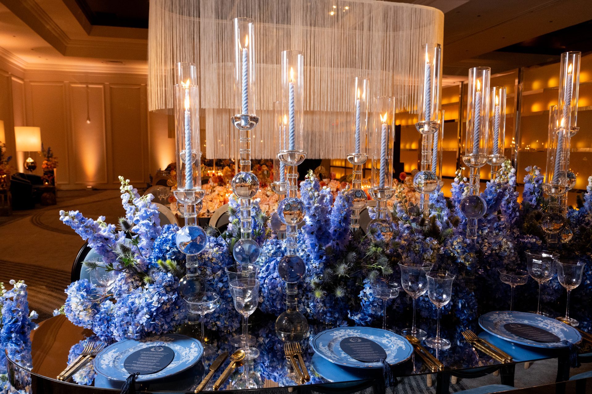 Blue delphinium, blue plates and a crystal chandelier at an event in the Horizon Ballroom